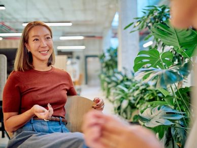 Woman smiling and talking in a modern office.