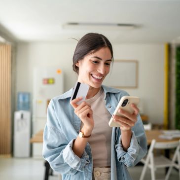 Mujer feliz con tarjeta y móvil.