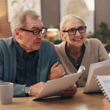 Elderly couple reviewing documents together.