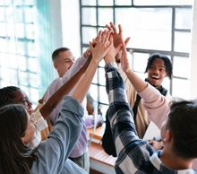 Diverse hands joined together symbolizing unity and teamwork.