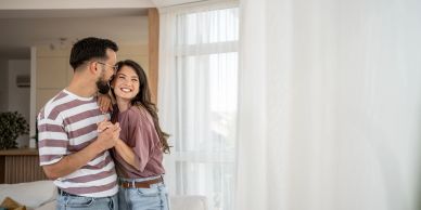 Happy couple dancing and smiling indoors.