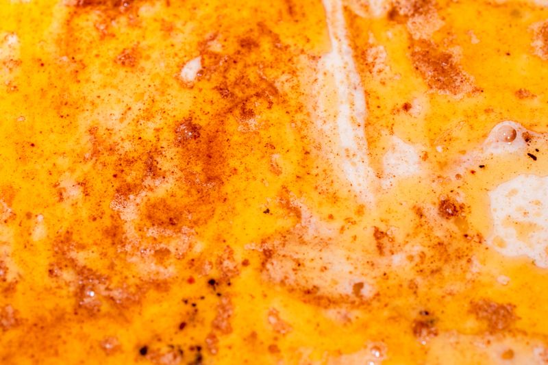 Close-Up of Melted Butter with Paprika and Spices Forming a Flavorful Swirl