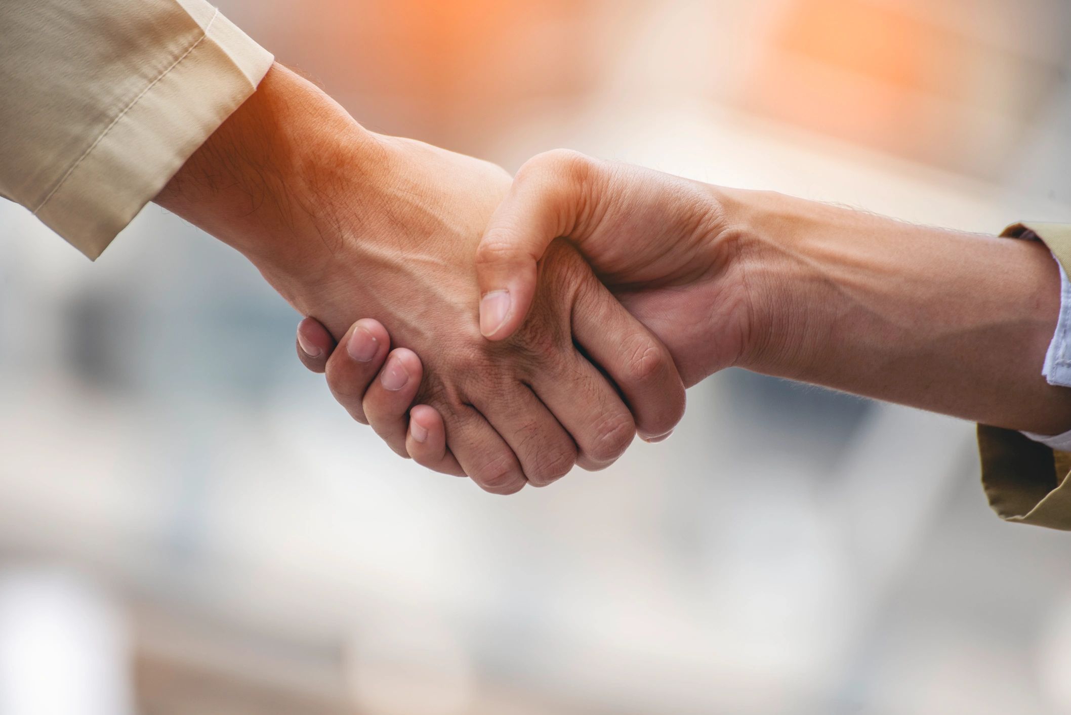 Close-up of two people shaking hands as a sign of agreement.