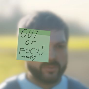 Sticky note saying "Out of focus today" in front of a blurred man.