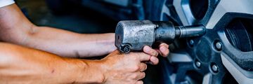 Hand using a roller to patch a tire.