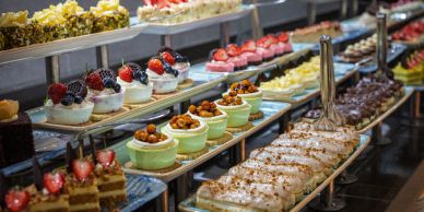 Assorted desserts displayed on trays in a bakery.