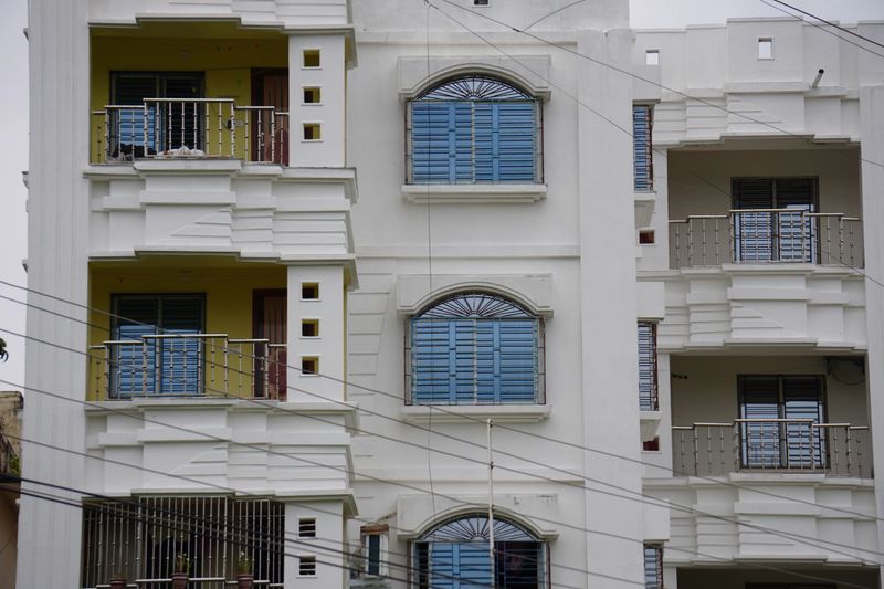 A multi-story residential building, likely an apartment complex featuring prominent balconies and arched windows