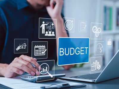 Businessman calculating budget with digital icons.