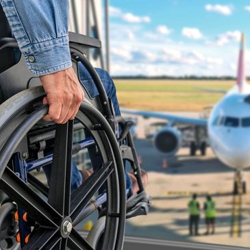 Person in wheelchair waiting near airplane at airport.