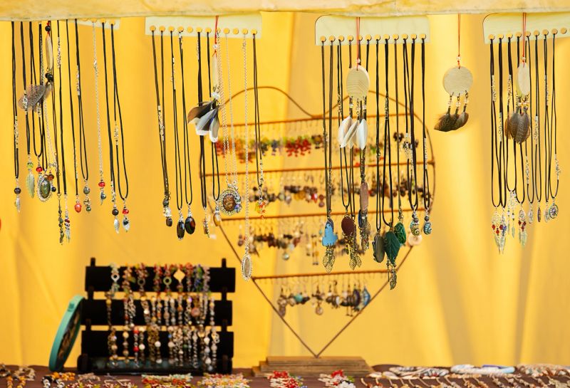 Handcrafted necklaces and earrings displayed at a market stall. Homemade jewelry for sale for small business and craft fair.