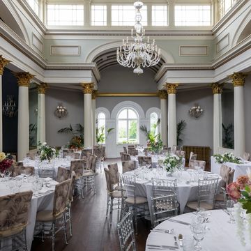 Elegant banquet hall with round tables and chandelier.