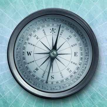 A vintage compass on a blue grid background.