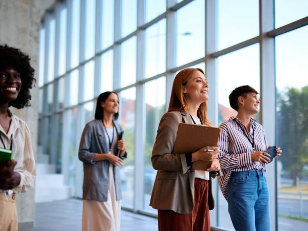 Diverse group of professional women standing in a bright modern office space.
