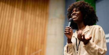 Confident woman speaking passionately into a microphone.