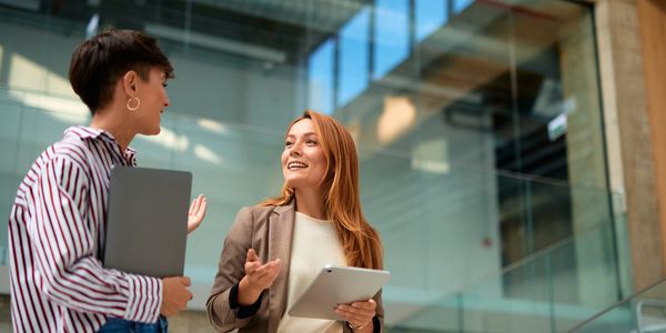 Close-up of hands typing on a laptop keyboard with a cup nearby.