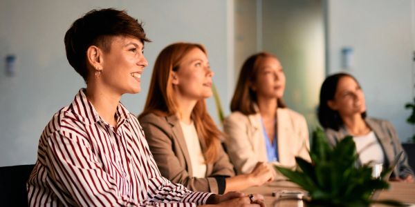 Four women attentively listening in a meeting.