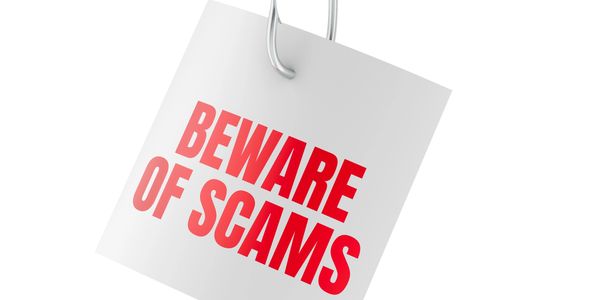White tag with red text reading Beware of Scams.