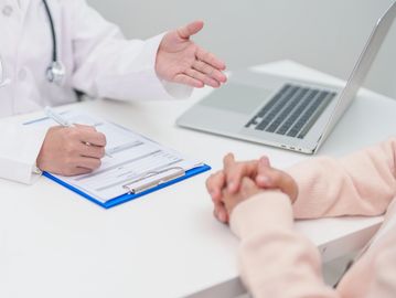Doctor discussing medical information with a patient in a consultation.