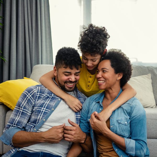Happy family sharing a joyful moment together on a couch.