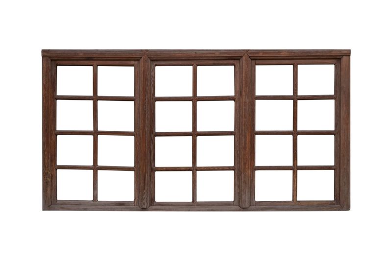 Large vintage wooden window frame with three sections is isolated.