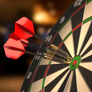 Three darts perfectly hit the bullseye on a dartboard.