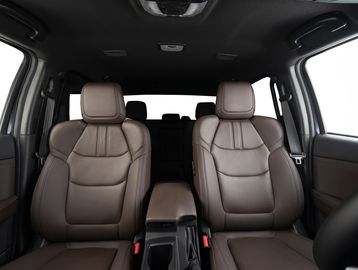Front view of a car interior with brown leather seats and central armrest.