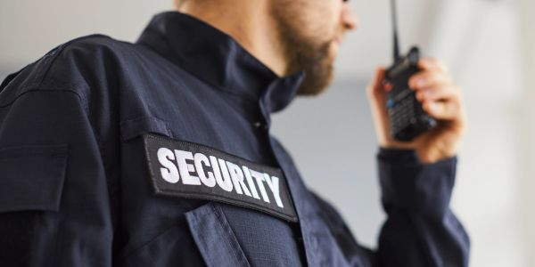 Security guard speaking into a walkie-talkie.