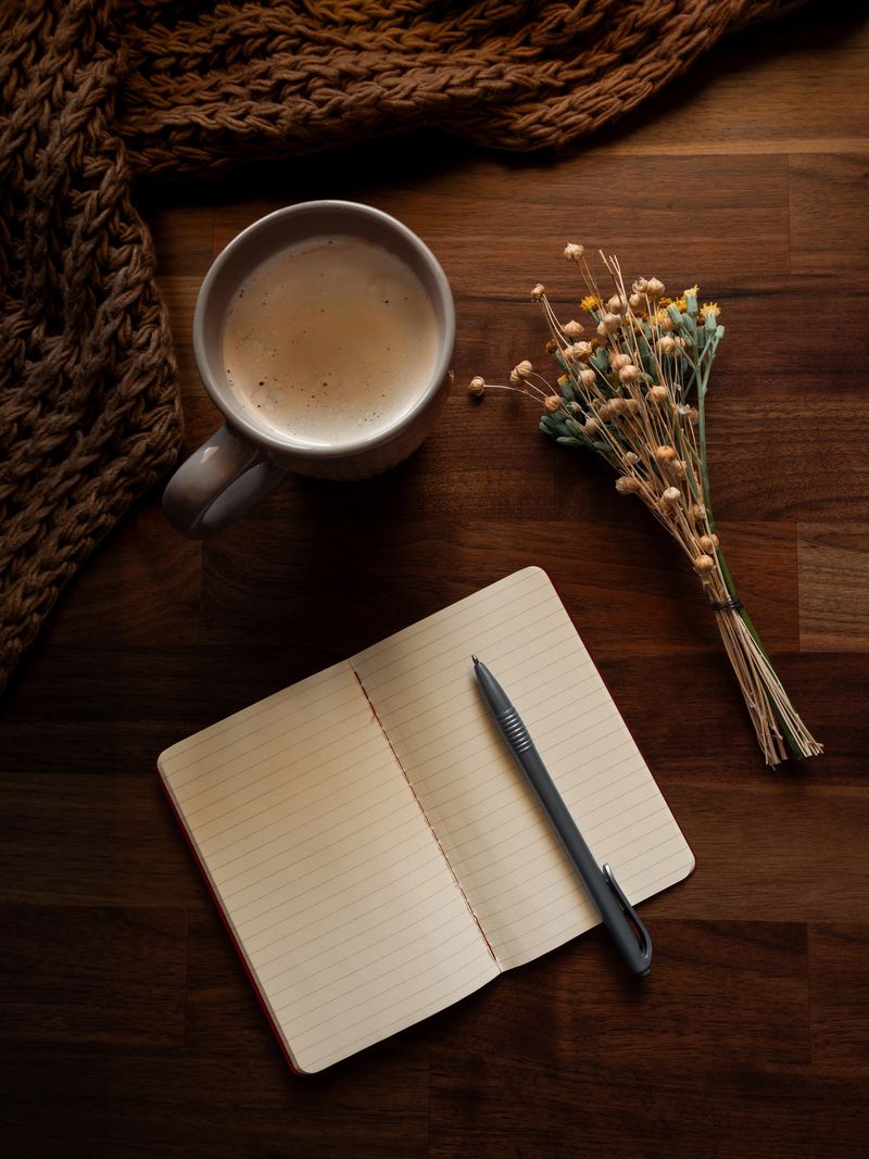 Cozy writing setup with cappuccino, notebook, and autumn details in Quiaios, Coimbra, Portugal
