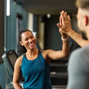 Two people giving a high-five at the gym.