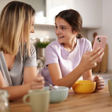 Mother and daughter sharing a joyful moment during breakfast.