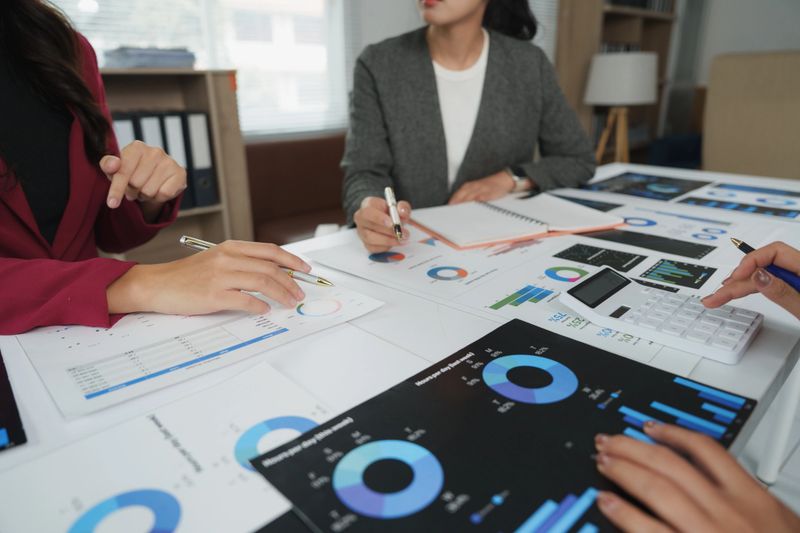 Business team analyzing financial charts and graphs, discussing company performance and making strategic decisions