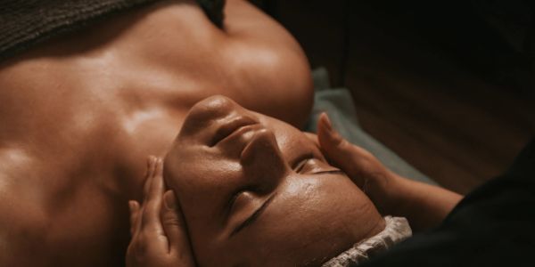 Person receiving a relaxing facial massage with eyes closed.