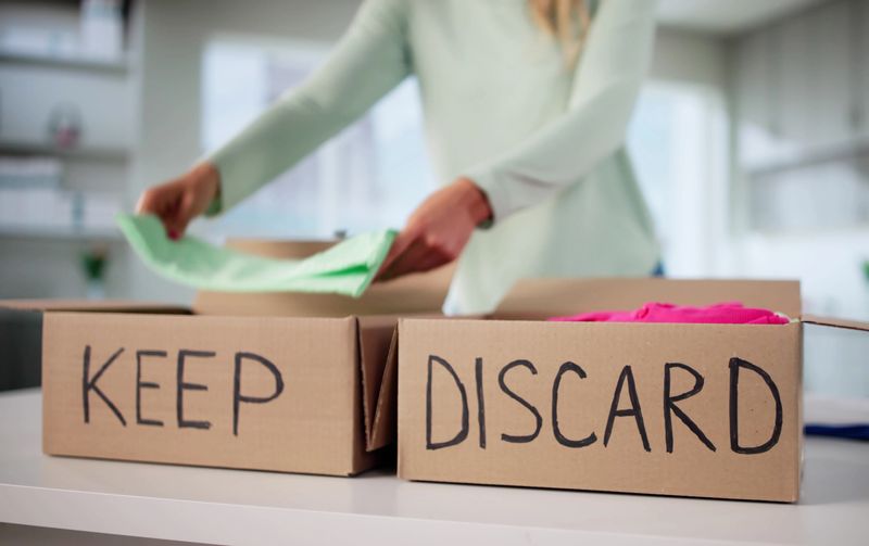 Organized Woman Sorting Through Wardrobe, Decluttering Clothes For Donation