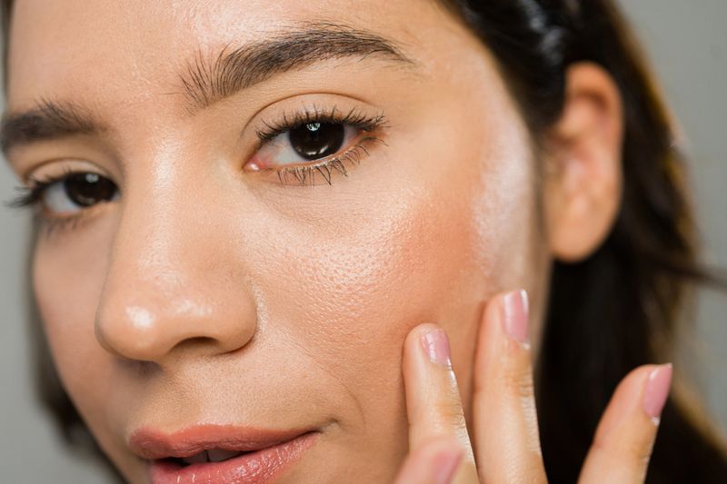 Young woman applying moisturizer to her face, highlighting the importance of skincare for a healthy and radiant complexion
