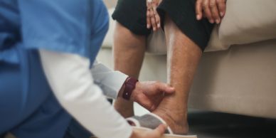 Nurse measuring elderly person's leg.