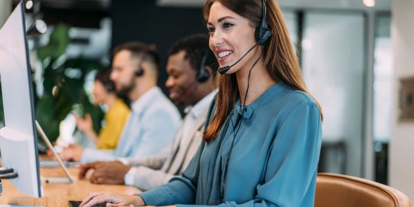 Female call center worker with a headset at her desk.
