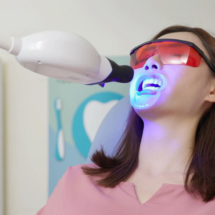 Patient receiving a violet LED whitening treatment