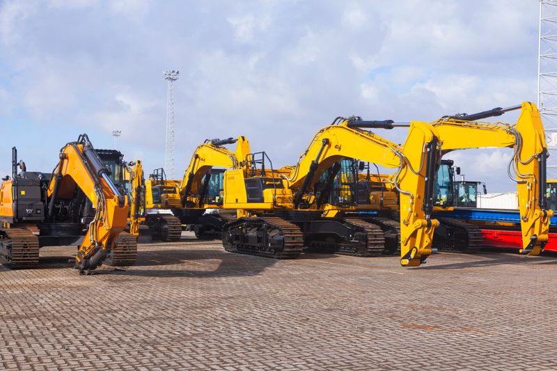 New yellow crawler excavators are parked on the site.