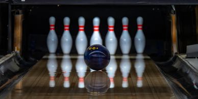 Bowling ball approaching pins on a lane.