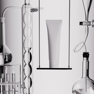 A blank cosmetic tube displayed among scientific glassware in a minimalistic lab setup.