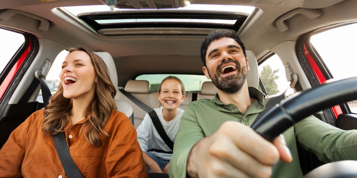 Happy family enjoying a car ride together.