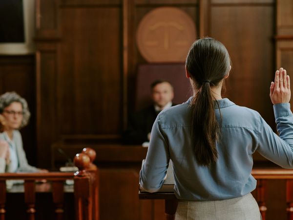 Woman swearing an oath in a courtroom.
