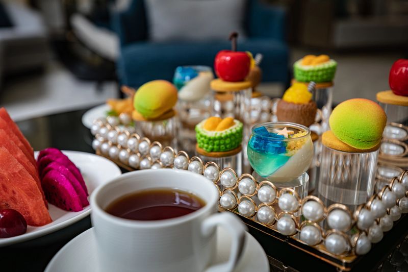 A collection of elegant desserts is artfully arranged on a reflective surface. A variety of exquisite pastries and desserts are presented before your eyes, showcasing vibrant colors and creatively designed presentations, making them perfect for special occasions or celebrations.