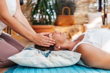 Therapist giving a head massage to a woman.