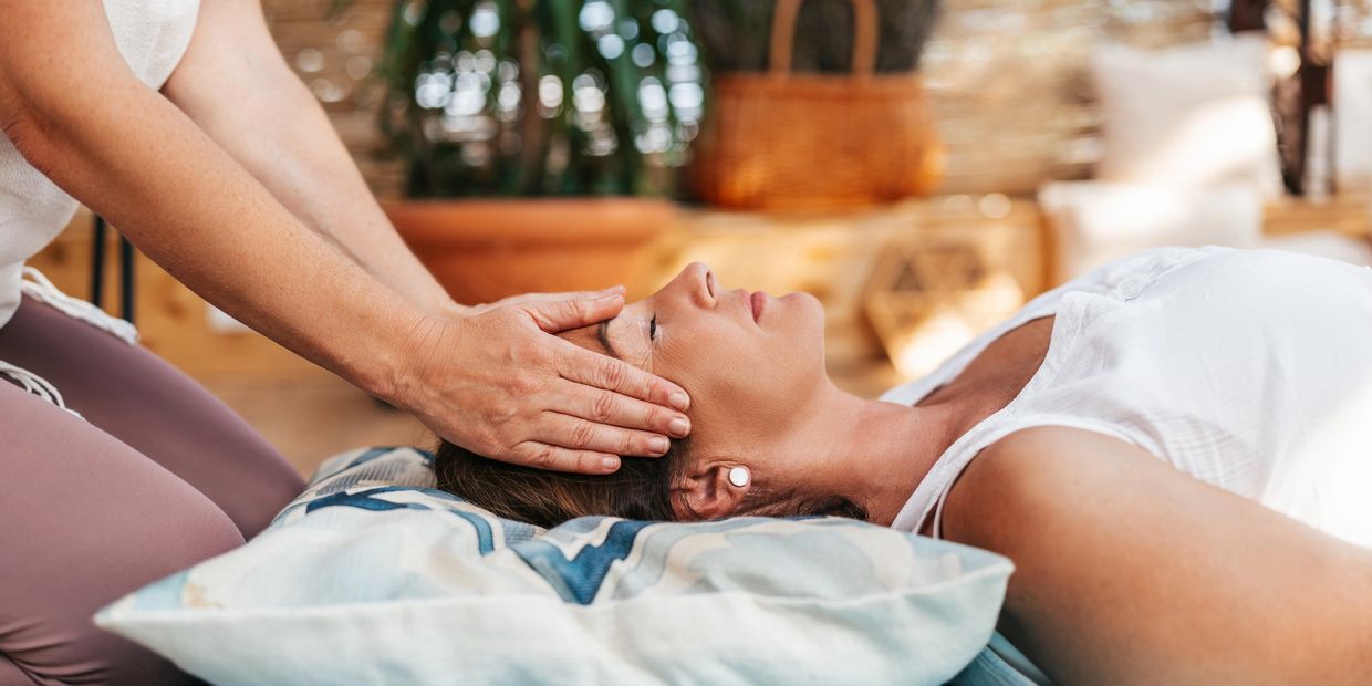 Woman receiving a relaxing head massage in a calm, cozy setting.