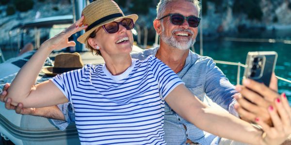 Happy older couple taking a selfie on a boat.