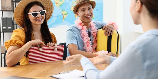 Happy couple planning their vacation at travel agency.