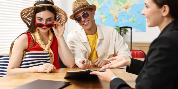 Couple consulting a travel agent at a desk.
