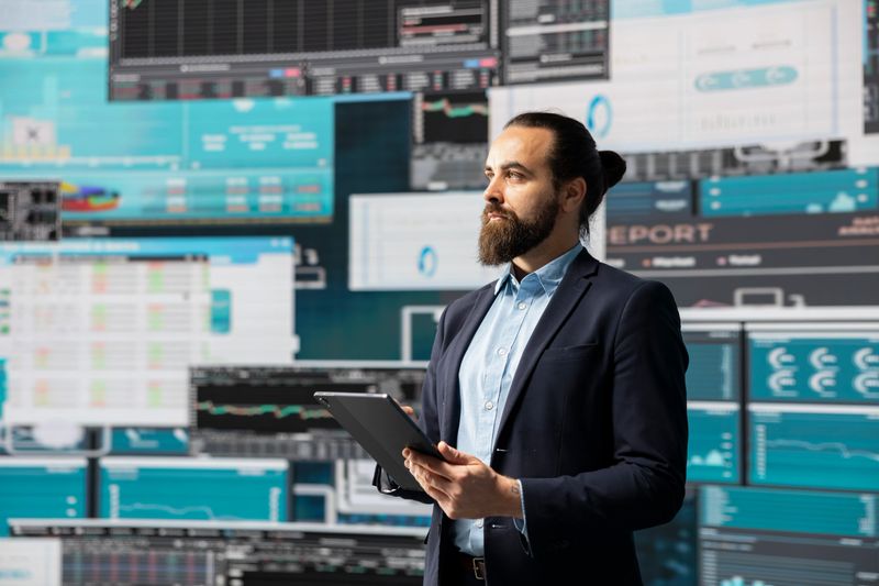Surrounded by fintech data and forecasting models, entrepreneur analyzes data and insight to drive business growth. Company performance and smart decision making through innovation.