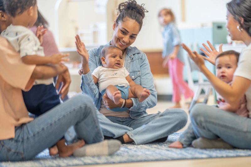 Parents and their young children enjoy interactive group activities in a preschool environment, fostering learning and connection.